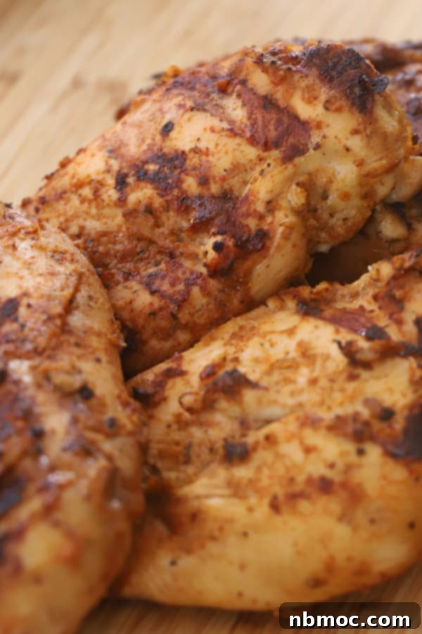 Restaurant-Style Chipotle Chicken Recipe 6 Grilled copycat Chipotle chicken breasts resting on a cutting board, ready to be sliced and served.
