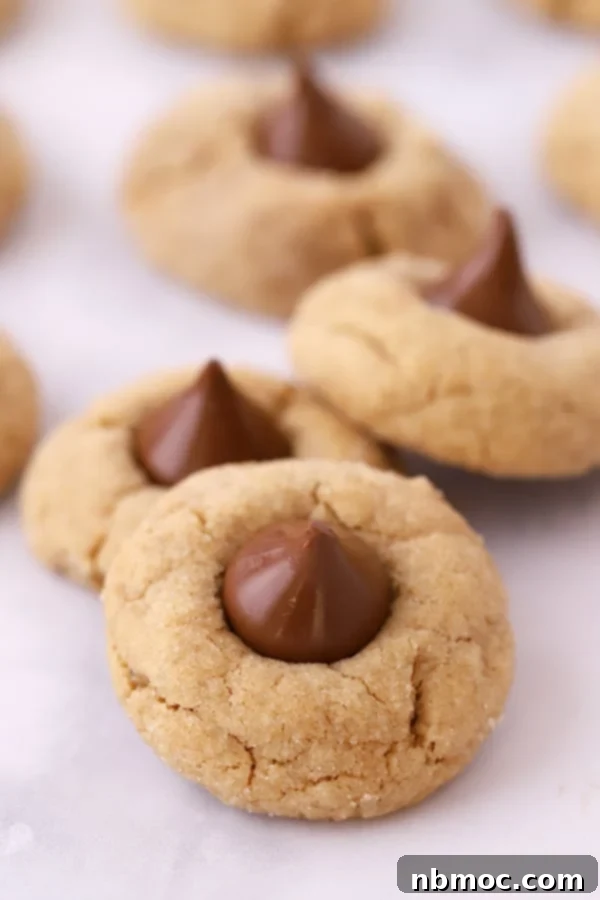 Peanut butter blossom cookies on parchment paper, ready to be enjoyed.