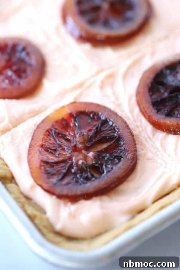 Sugar cookie bars featuring a decadent blood orange cream cheese frosting and delicate candied blood oranges.