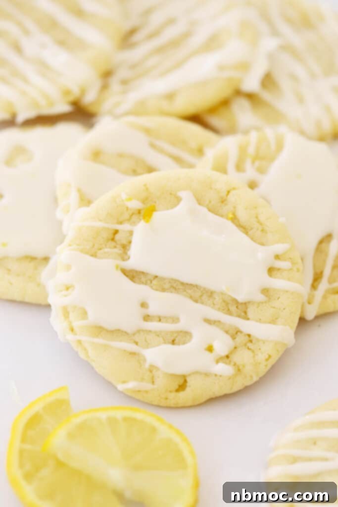 Glazed lemon cookies arranged on parchment paper, highlighting their light and fluffy texture.