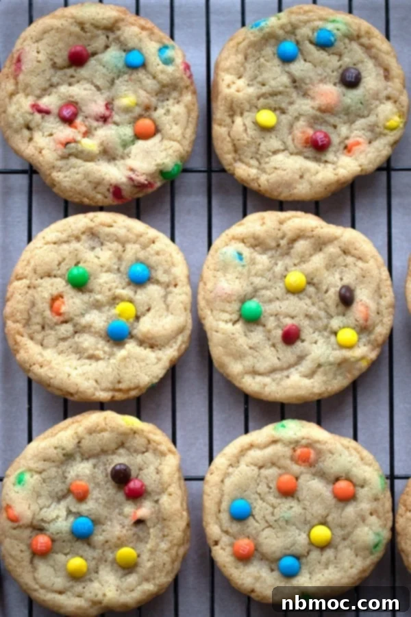 Chocolate M&M cookies cooling on a wire rack, showcasing their colorful appeal.