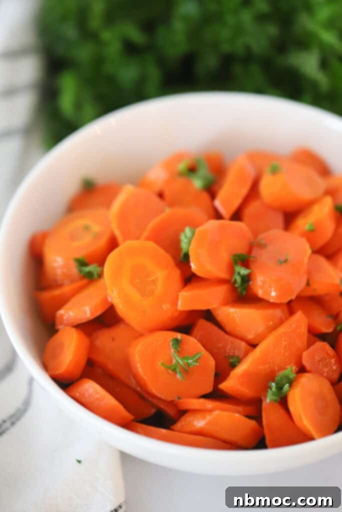 A close-up of beautifully glazed carrots in a serving bowl, showcasing their inviting sweetness and vibrant color, a truly easy side dish recipe.