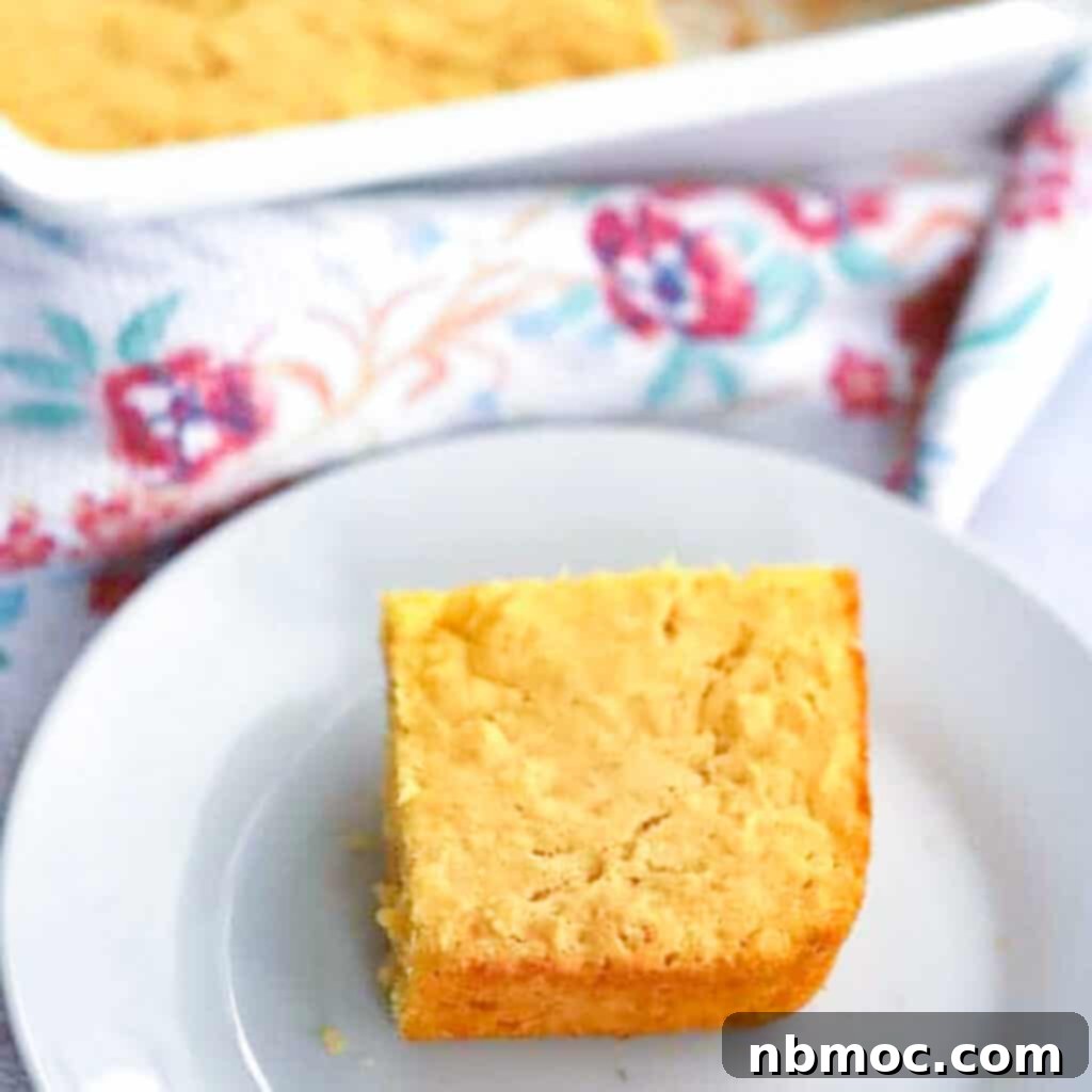 A pan of simple corn bread, freshly baked and golden, alongside a slice on a small plate, representing one of the best Thanksgiving side dishes.