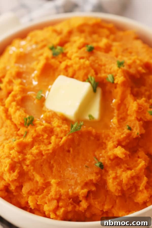 A bowl of mashed sweet potatoes, garnished with herbs, a perfect recipe for the holidays.