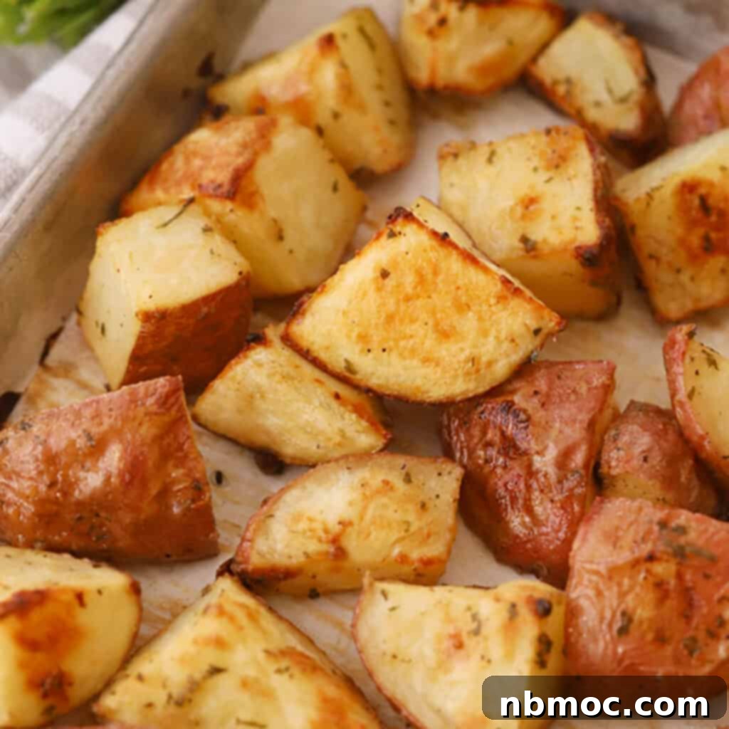 A baking sheet filled with golden-brown oven-roasted red potatoes, perfectly seasoned and ready to serve.