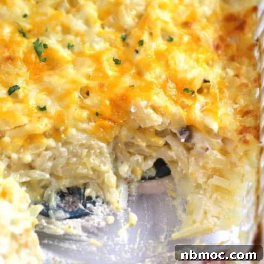 A bubbling cheesy potato casserole in a clear glass baking dish, showcasing its rich texture and golden-brown top, an easy and delightful cheesy potato recipe for any meal.