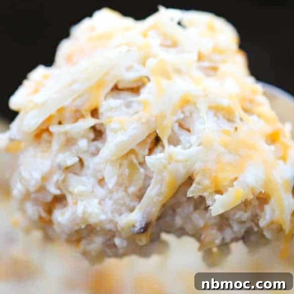 A large spoon scooping out creamy crockpot cheesy potatoes from the slow cooker, highlighting its comforting appeal.