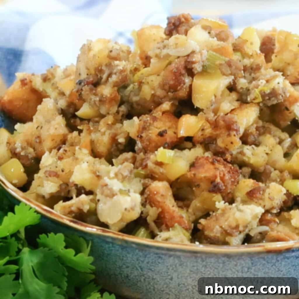 A bowl filled with golden-brown sausage apple stuffing, ready for a festive holiday dinner, showcasing its rich texture and ingredients.