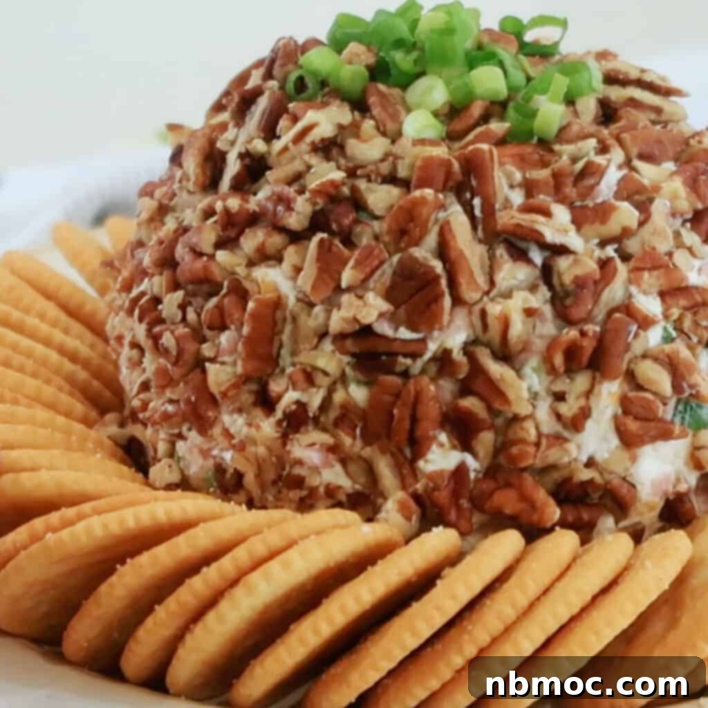 A beautifully presented Ham and Cheddar Cheese Ball on a serving tray, accompanied by a selection of Ritz Crackers, ideal for holiday entertaining.