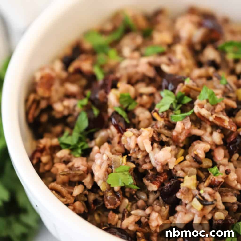 A serving dish filled with vibrant Thanksgiving wild rice, featuring pecans and cranberries, showcasing one of the best Thanksgiving side dishes.