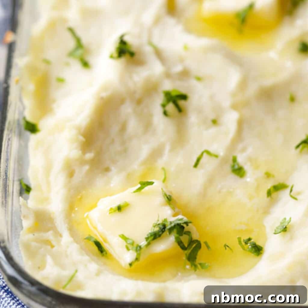 A glass baking dish filled with perfectly smooth make-ahead mashed potatoes, ready to be served or stored. This make-ahead mashed potatoes recipe simplifies holiday meal prep.