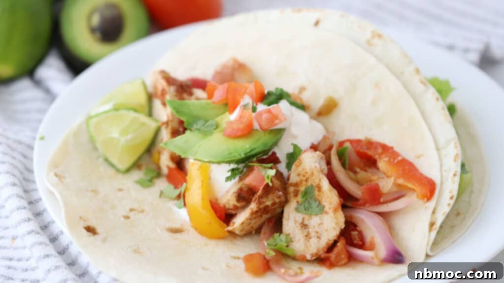 chicken fajita on a flour tortilla topped with guacamole and sour cream