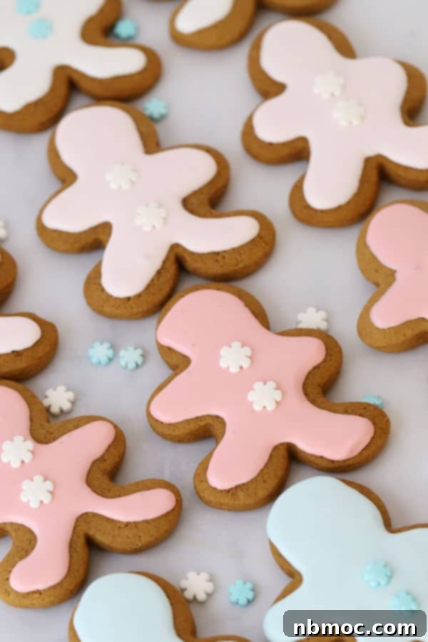 Perfectly Spiced Gingerbread Men 4 Decorated gingerbread man cookies covered with gingerbread man frosting and little snowflake sprinkles.