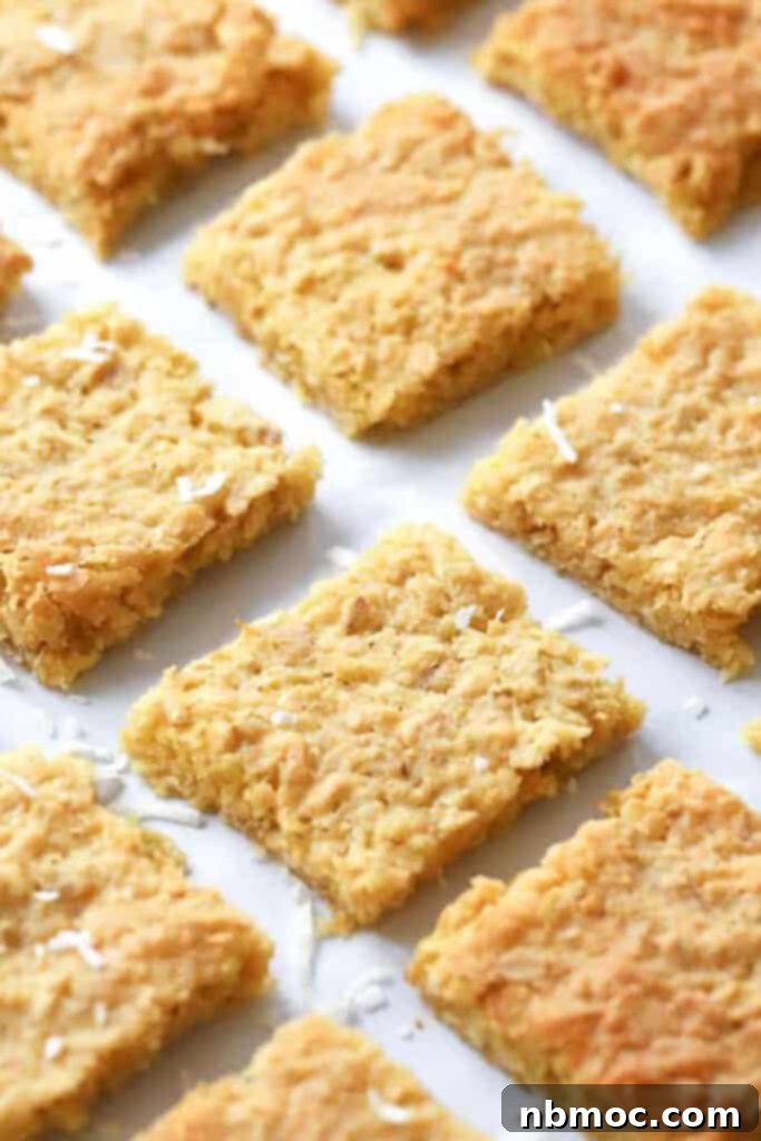 Coconut Bar cookies cut into squares and lined up a baking sheet.