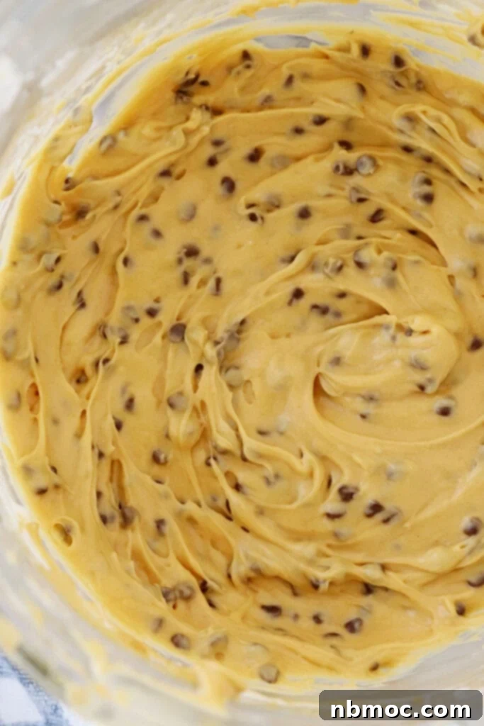 buckeye dip in a mixing bowl with mini chocolate chips, buckeye recipe with cream cheese, best cream cheese dip recipes.