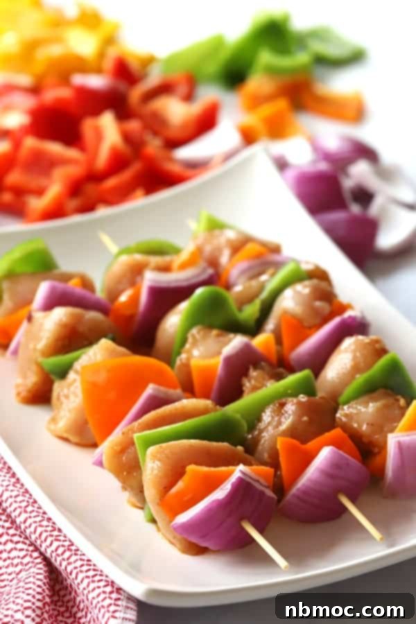 Southwest chicken shish kabobs on a plate, marinated and ready to be grilled.