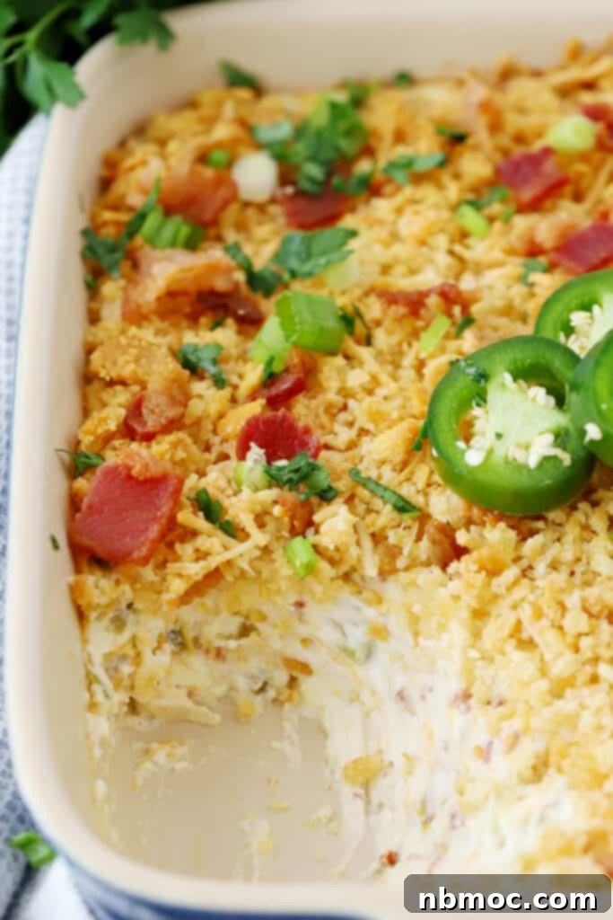 Jalapeño Popper Dip with bacon, a warm and creamy appetizer served in a rustic baking dish with dippers.