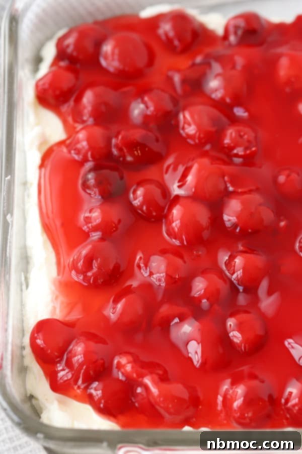 A baking dish full of cherry cheesecake dip made with cherry pie filling, ready to be served.