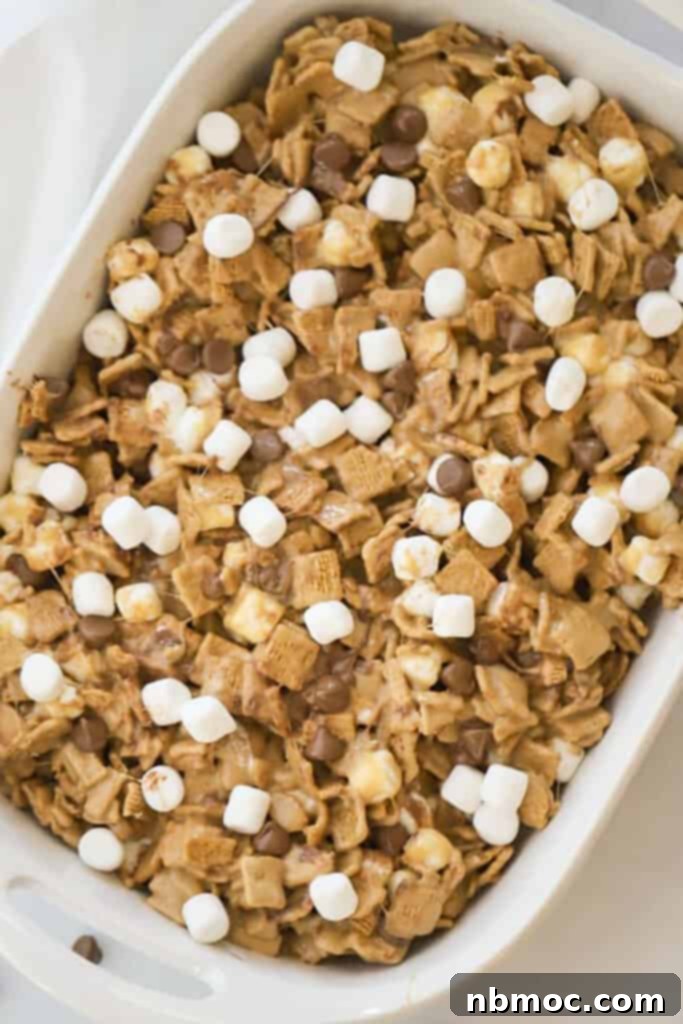 A baking dish full of golden graham bars with chocolate chips, peanut butter, and mini marshmallows.