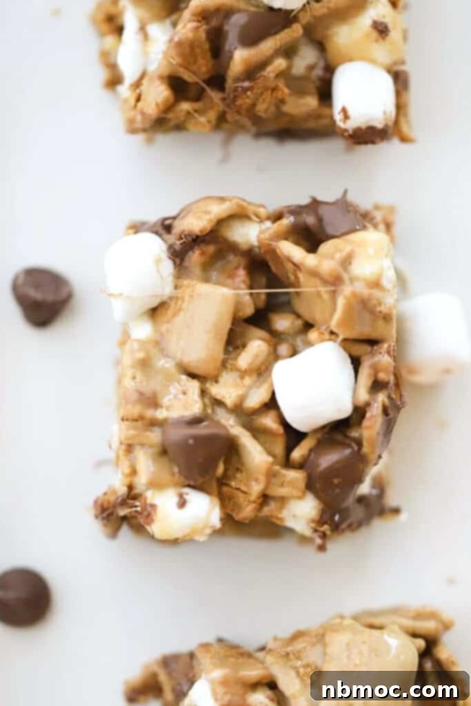 S'mores Bars on a tabletop sprinkled with mini marshmallows and chocolate chips.