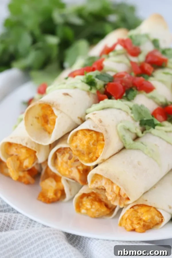 Freshly baked buffalo chicken taquitos on a serving platter, with various dipping sauces.