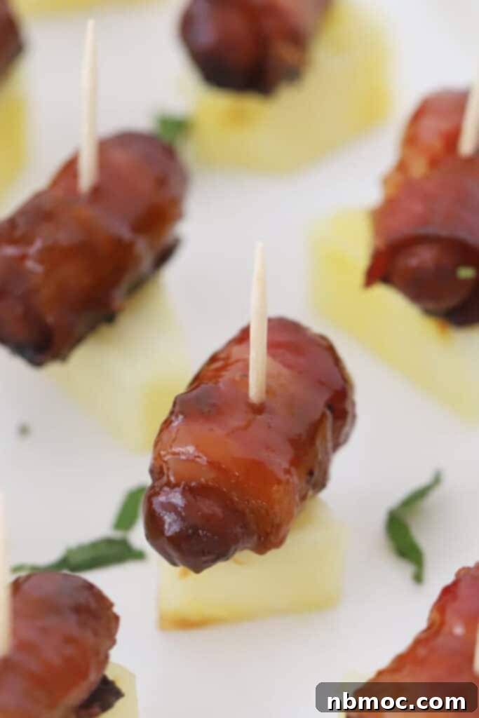 Crispy Bacon Wrapped Smokies 2 bacon wrapped smokies recipe served on a piece of pineapple, bacon wrapped cocktail weenies.