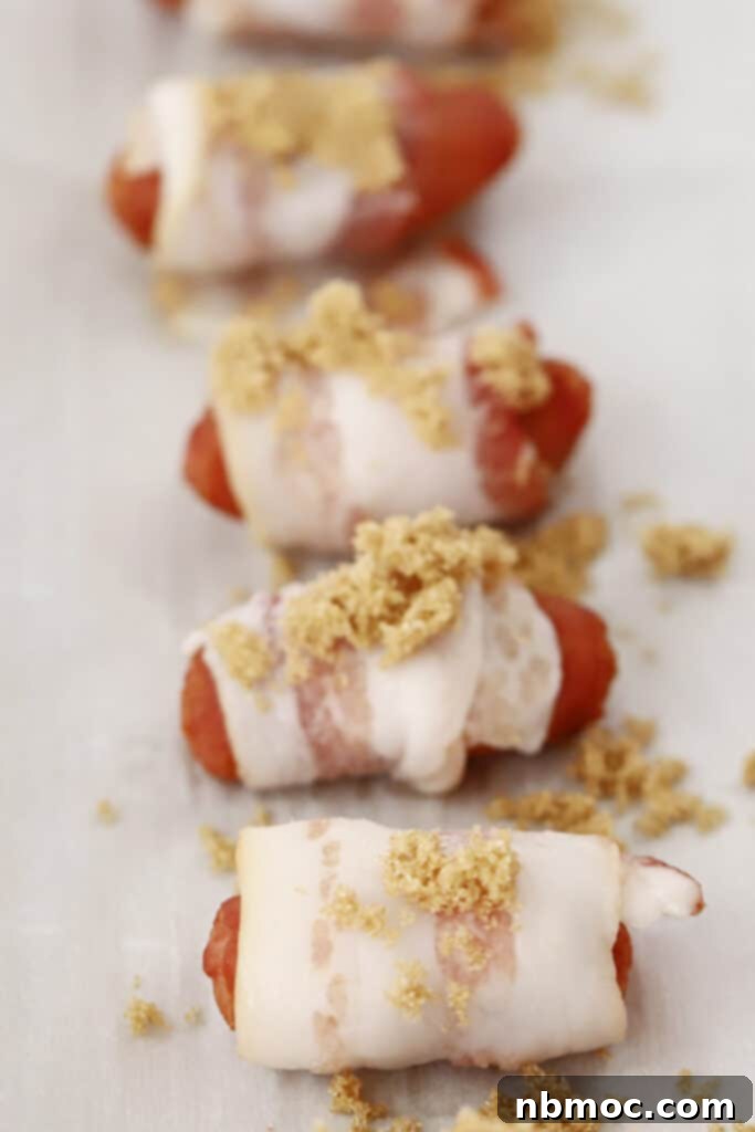 Crispy Bacon Wrapped Smokies 4 Bacon wrapped wieners topped with brown sugar, ready to cook.