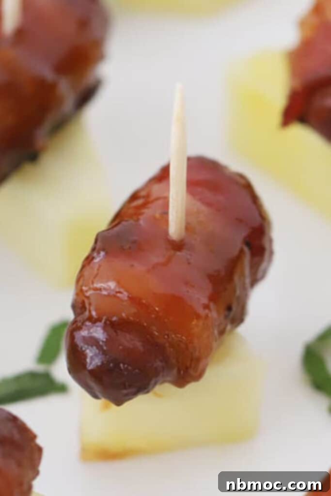 Crispy Bacon Wrapped Smokies 6 bacon wrapped smokies served on a piece of pineapple.