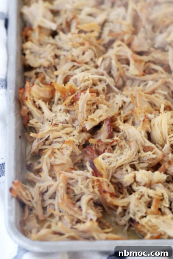 Crispy slow cooker pork carnitas on a baking sheet, ready to be served in your favorite carnitas tacos with various toppings.