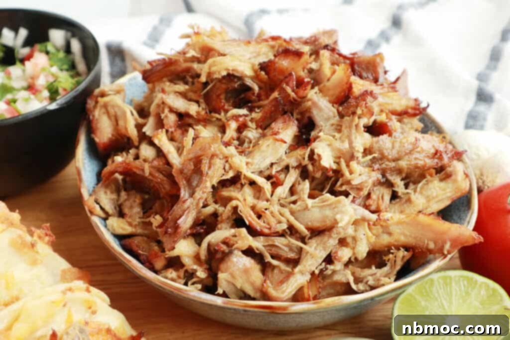 A bowl filled with tender, crispy slow cooker carnitas, showcasing the perfect balance of textures in this easy carnitas recipe.