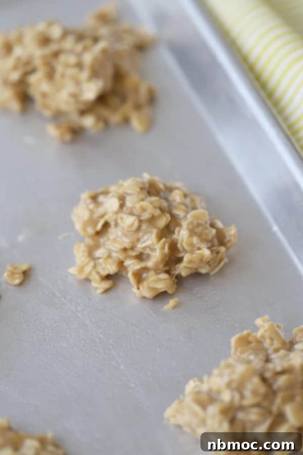A baking sheet filled with freshly made No-Bake Peanut Butter Cookies, perfectly round and ready to cool.