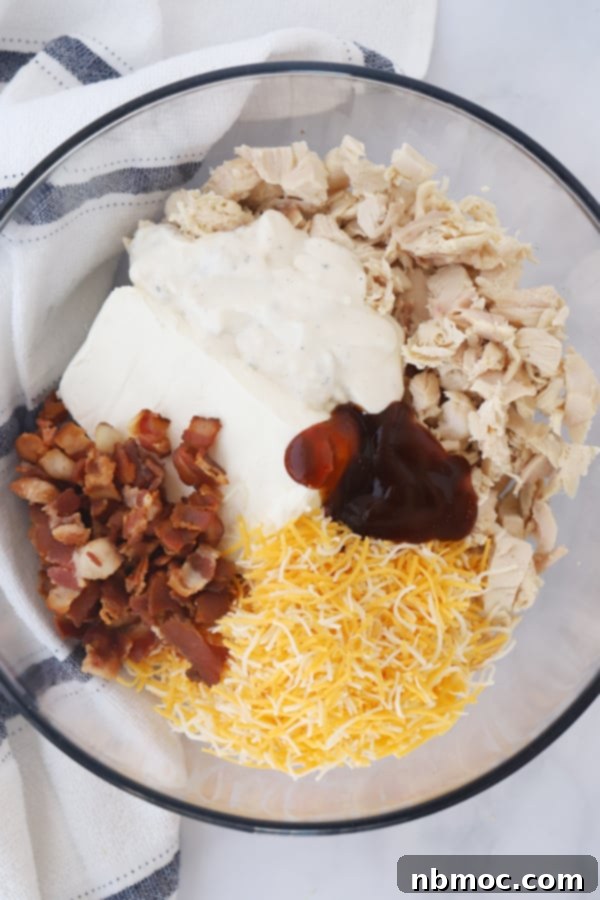 Golden Crisp BBQ Chicken Taquitos 3 The creamy, savory filling for baked chicken taquitos in a bowl, featuring BBQ chicken, ranch, bacon, cream cheese, and shredded cheese.