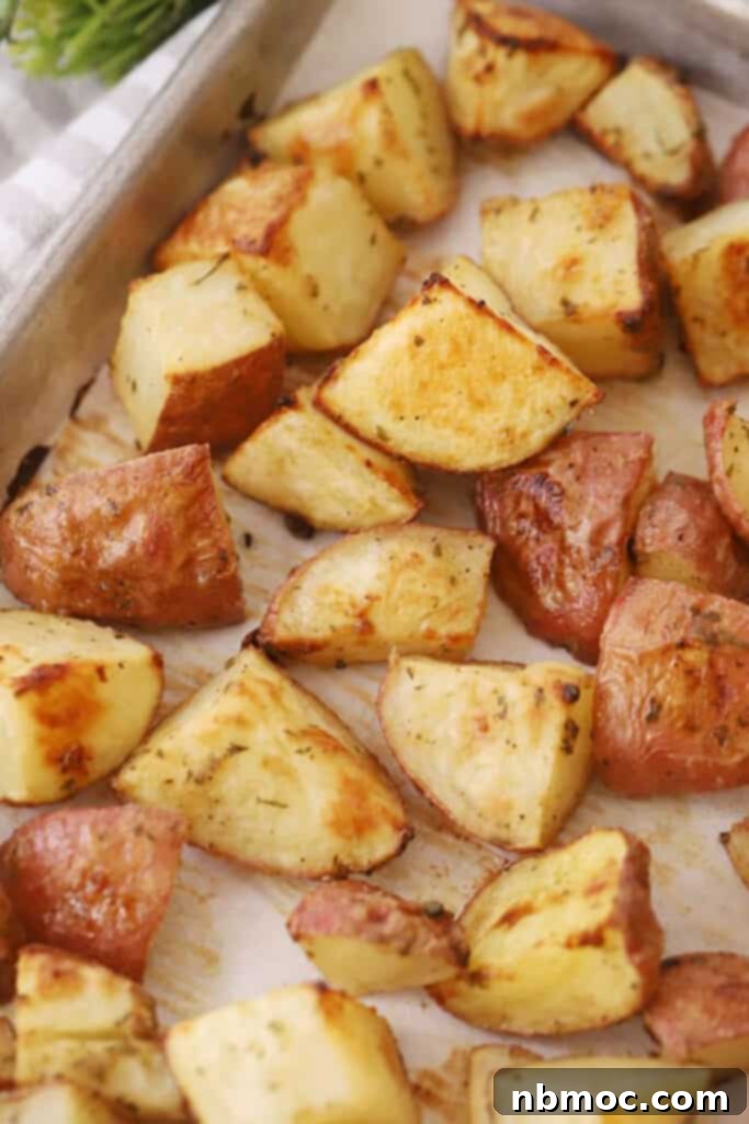 Decadent Garlic Herb Cheesy Potatoes 4 A sheet tray with garlic cheesy roasted potatoes.