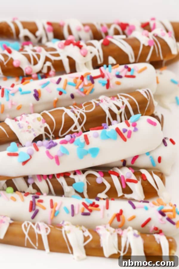 caramel and chocolate covered pretzel rods with decorative sprinkles.