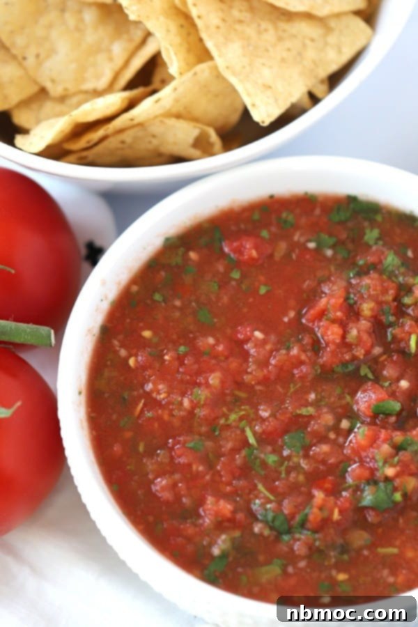 fresh salsa in a bowl with a side bowl of tortilla chips.