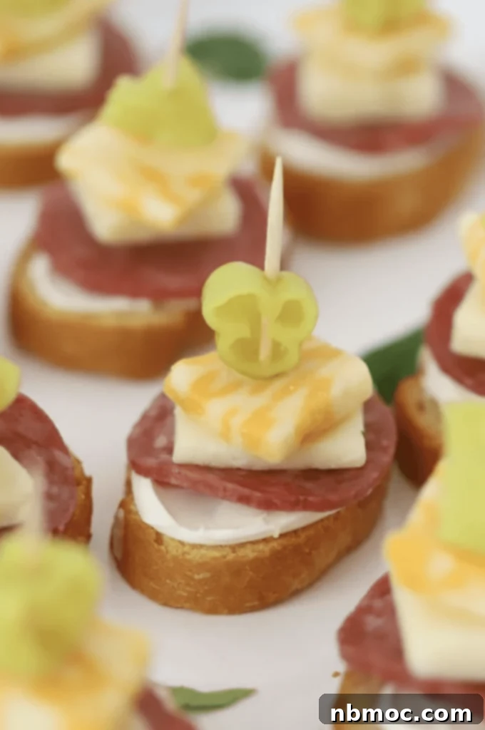 A close up of an Italian appetizer sized kabob made with bread, meats and cheeses.