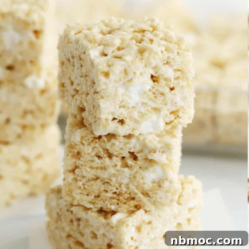 Classic Rice Krispies Treats cut into squares and stacked on top of each other.