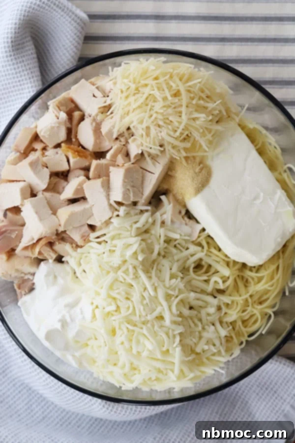 Ingredients to make this Chicken Spaghetti casserole recipe in a glass mixing bowl.