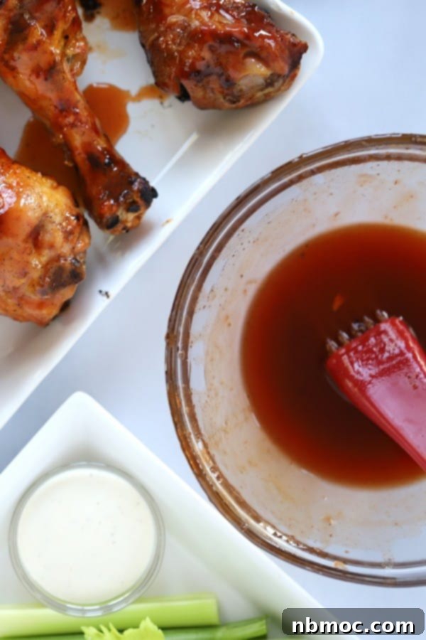 Craft Your Own Buffalo Sauce 2 A plate of chicken drumsticks with homemade buffalo sauce brushed over the top, highlighting its perfect glaze and inviting color.