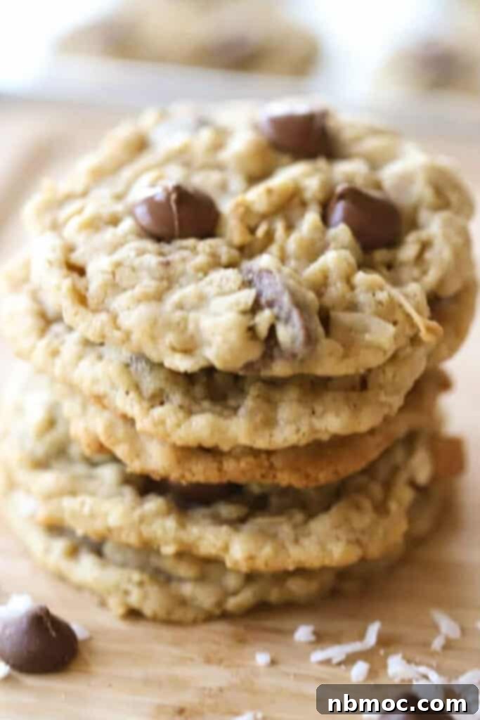A stack of perfectly baked oatmeal coconut chocolate chip cookies, showcasing their chewy texture and generous chocolate chips.
