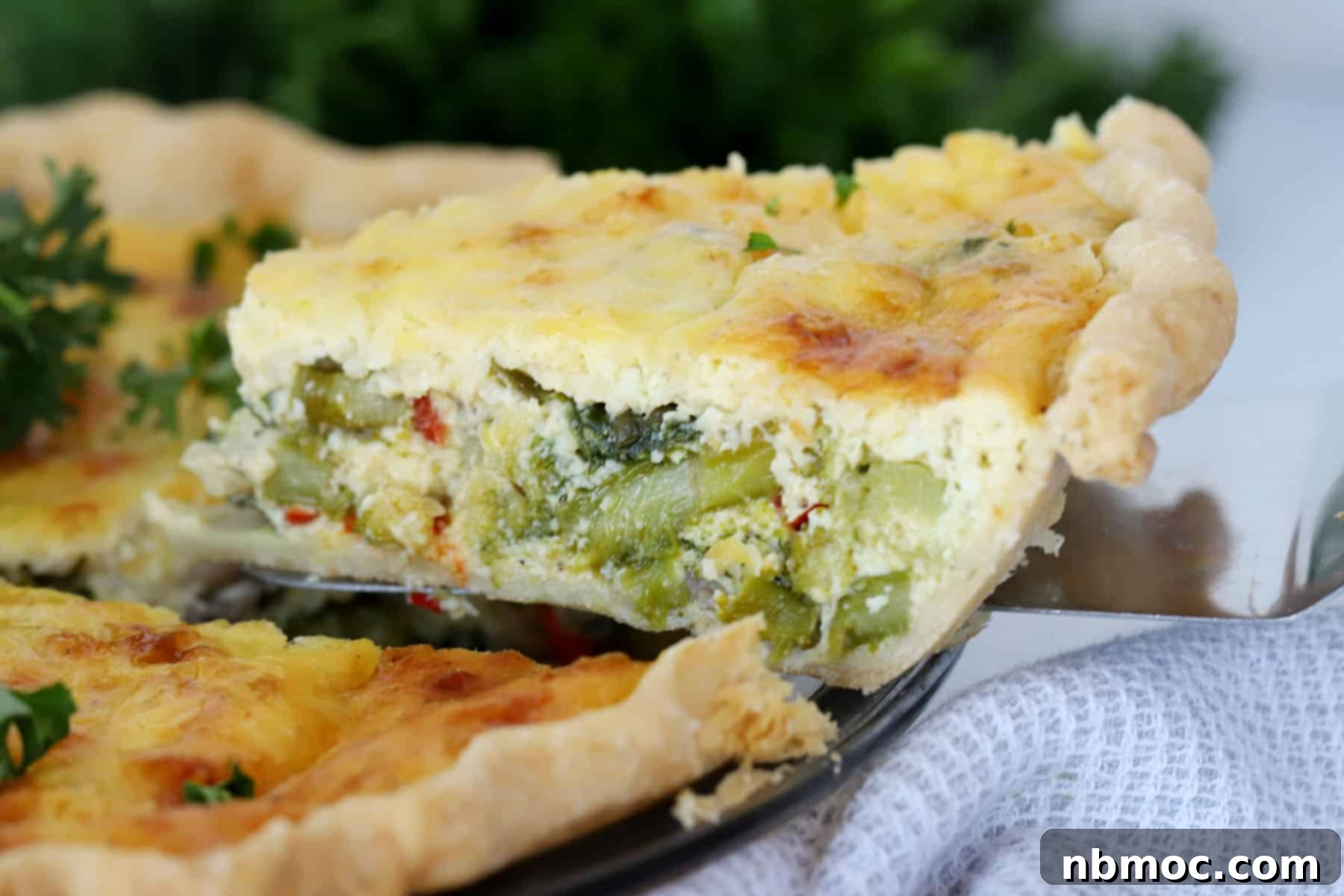 Garden Harvest Quiche 4 A slice of veggie quiche being removed from a pie dish; best recipe for vegetable quiche.