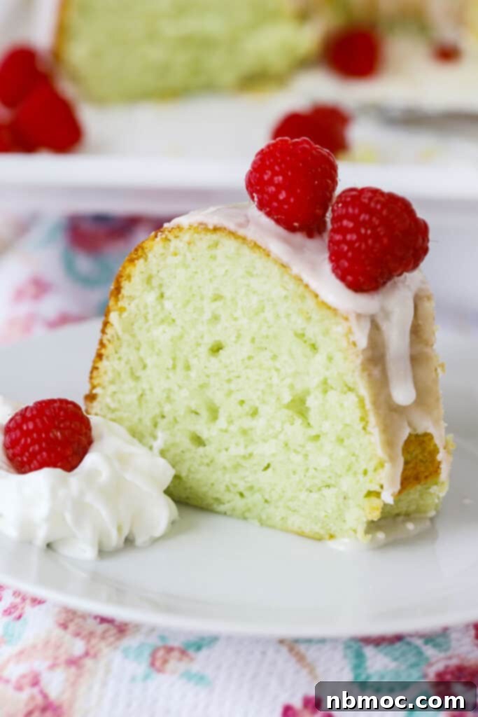 Verdant Lime Crown 5 A slice of lime cake topped with raspberries and glaze.