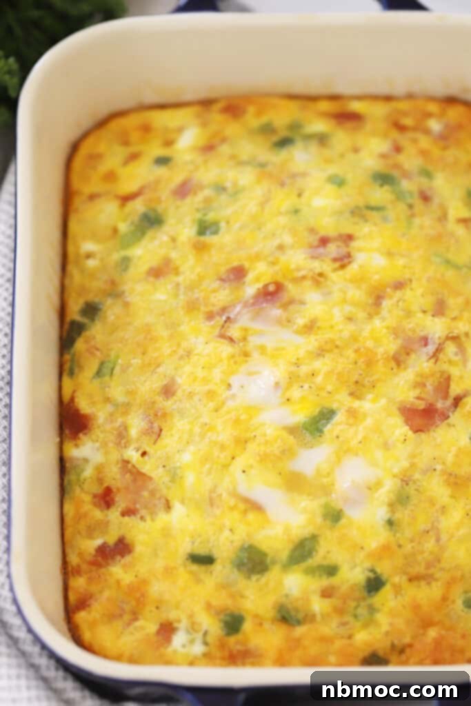 Simple Denver Omelet Breakfast Bake 2 Easy Baked Denver Omelette Casserole, baked in a glass baking dish, sliced and ready to serve.