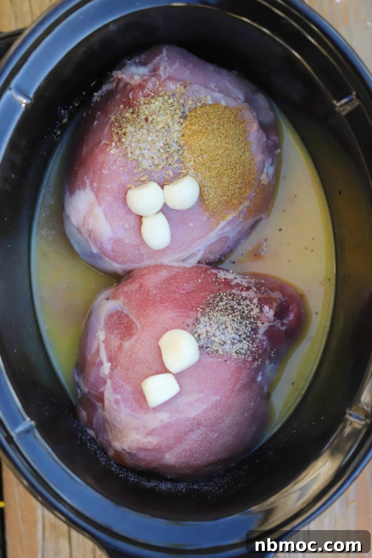 Crispy Slow Cooker Carnitas Tacos 4 Pork roast in a slow cooker along with garlic, broth and spices, ready for cooking.