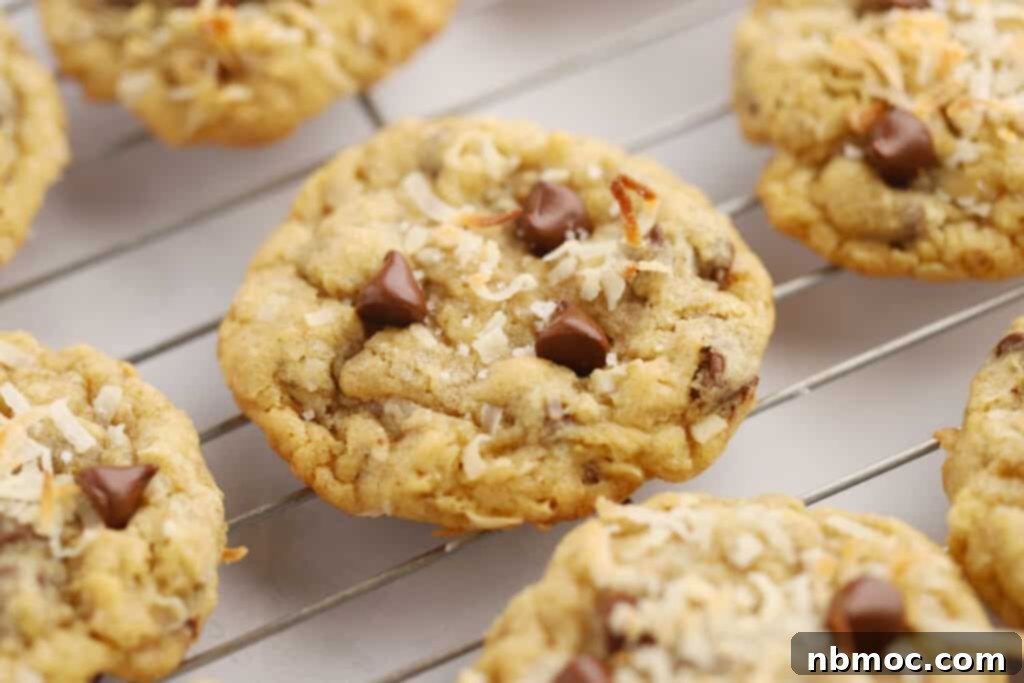Simply Delicious Chewy Cowboy Cookies 4 Cowboy cookies with coconut cooling on a wire rack.