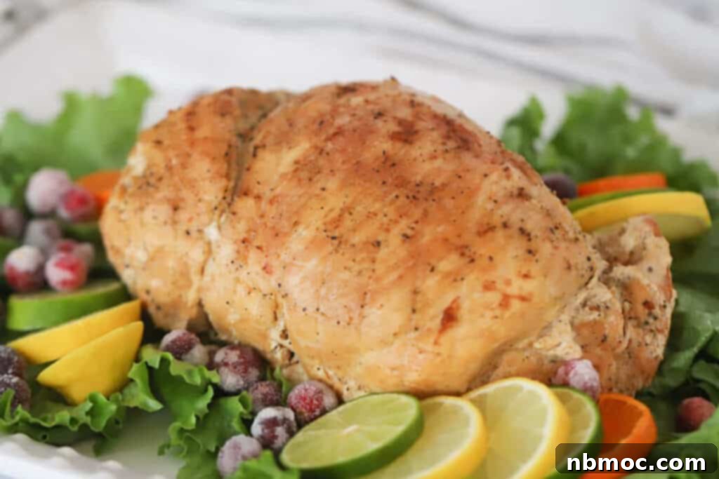 A perfectly cooked boneless turkey breast, beautifully golden and sliced, presented on a platter with fresh citrus garnishes and crisp lettuce leaves.