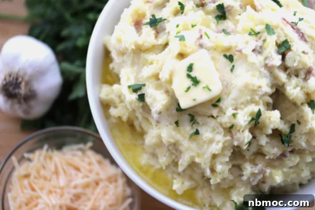 A bowl of creamy Garlic Parmesan Mashed Potatoes, beautifully topped with a melted pat of butter, ready to be enjoyed.