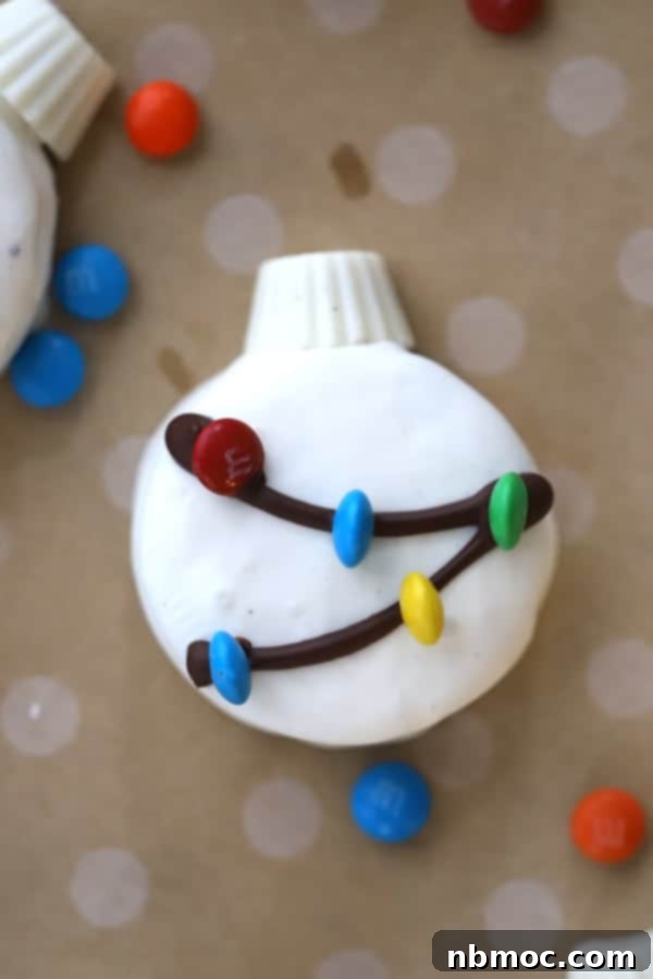 White Chocolate covered Oreos, decorated with dark chocolate drizzle and M&Ms to look like Christmas tree ornaments. A perfect festive treat for the holidays.