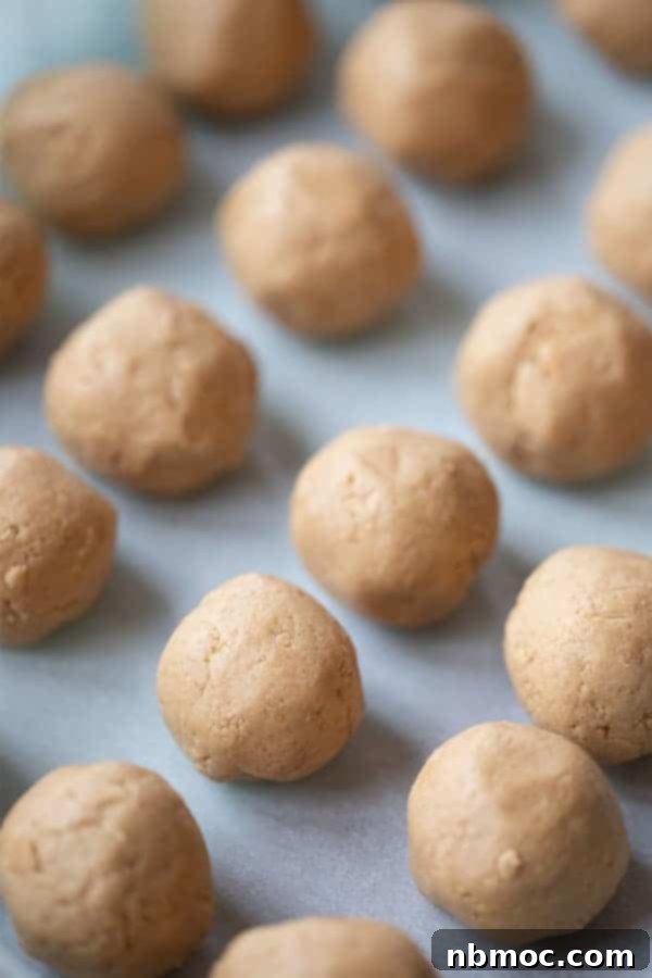 A baking sheet with rows of perfectly formed peanut butter Buckeyes, half-dipped in chocolate, ready to be enjoyed.