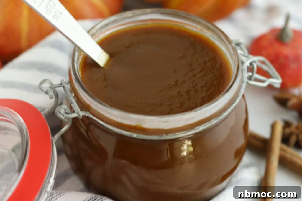 A small glass jar filled with spiced pumpkin syrup.